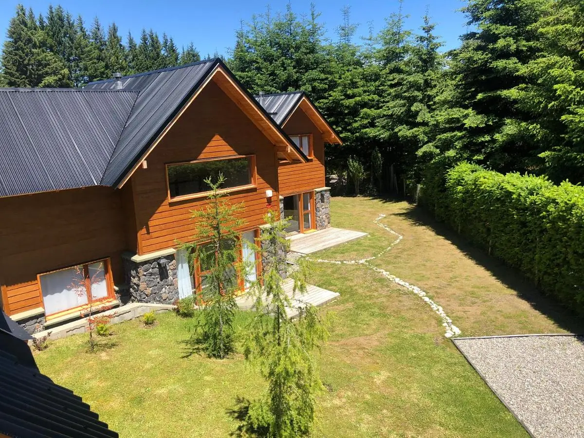 Two wood and stone cabins surrounded by gardens