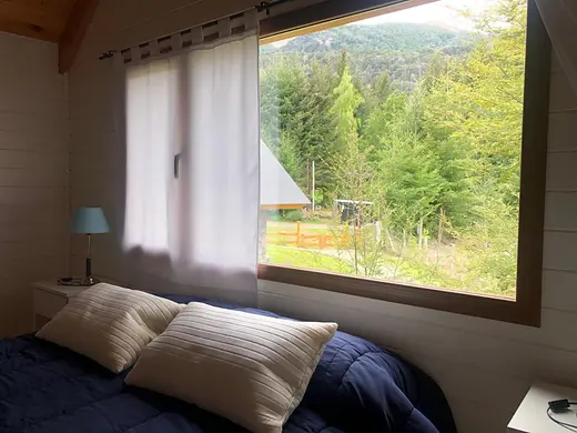 Bedroom with a large window onto the forest